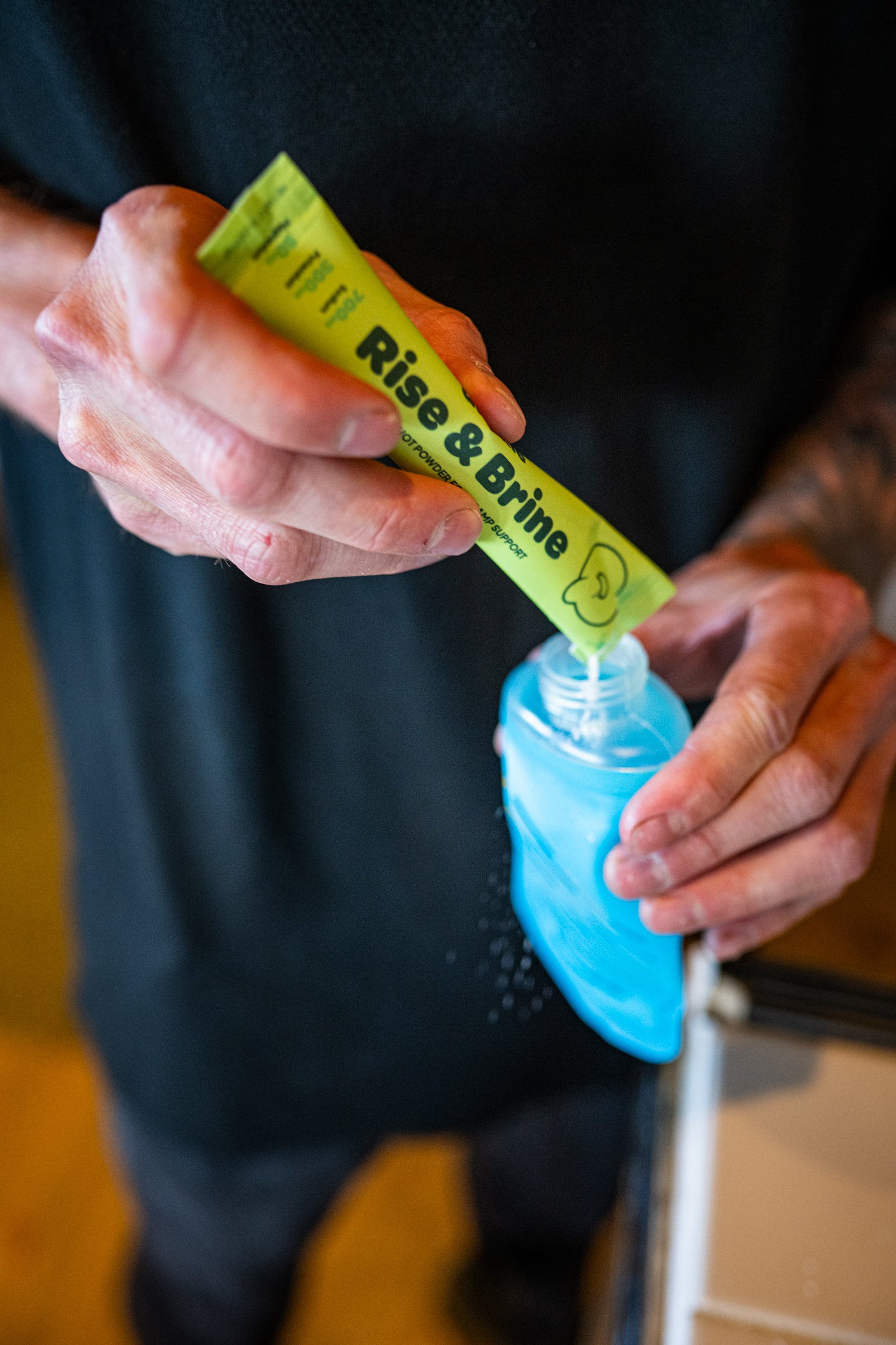 Quickle stick pouring powder into a soft flask with a small amount of water